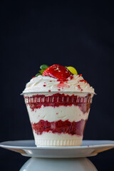 Mousse and pot cake, chocolate, strawberry and other creams, sugared strawberry, with chocolate bonbon, spoon, fabric, rustic wood