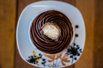 Mousse and pot cake, chocolate, strawberry and other creams, sugared strawberry, with chocolate bonbon, spoon, fabric, rustic wood