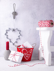 [Описание].Romantic background. Postcard with  wrapped presents, hearts, candle, bikers twine against  grey  textured  wall.  St. Valentines day postcard. Place for text.. - 556740696