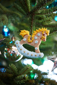gingerbread rocking horse decorated with icing hanging on a pine tree as a Christmas ornament decoration, Canada