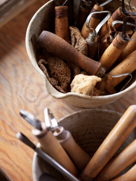 pottery making tools for cutting, edging, trimming, and sponging clay standing in clay pots, Canada