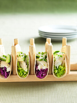 Fish Tacos with Red Cabbage and Green Cabbage in Soft Taco Shells, topped with Sour Cream, Avocado and Jalapeno