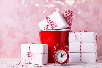 Postcard with  wrapped boxes with presents and red clock against  pink textured  wall. Scandinavian style. Place for text.