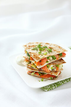 Stack of Smoked Salmon Quesadillas with Artichoke Hearts, Cream Cheese, Dill, Green Onions, Spinach, and Tomatoes on Whole Wheat Tortillas