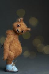 Cute teddy bear isolated on light background. Holiday glowing backdrop. Defocused background with...