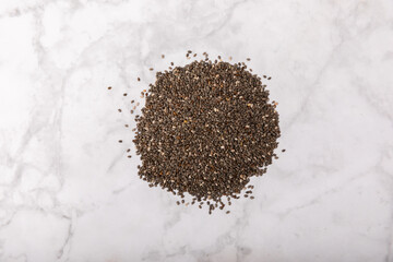 Chia seeds on a white marble background. Superfood. Healthy food. Diet. Antioxidant. Place for text. Place to copy.