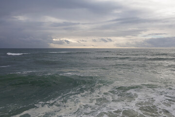 Minimalist sea and Atlantic ocean - wavy water with waves and cloudy overcast sky. Nature and natural elements.