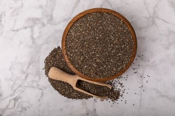 Chia seeds in bowls and wooden spoons on a white marble background. Superfood. Healthy food. Diet. Antioxidant. Place for text. Place to copy.