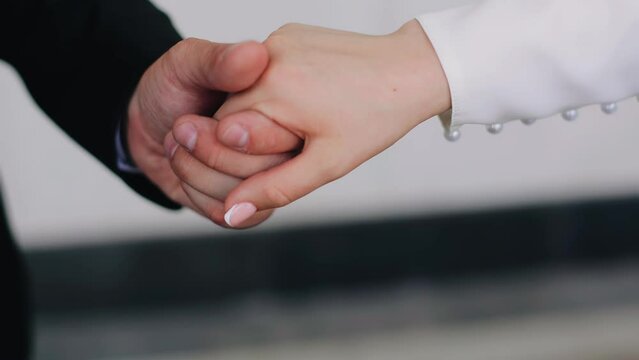 The guy gently takes his girlfriend's hand. Close-up shooting of lovers' hands