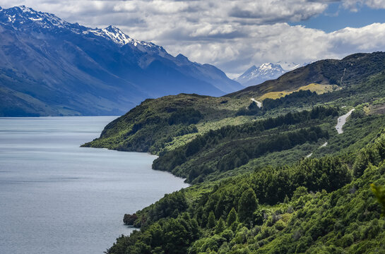 A winding road leads to the Bennets Bluff Lookout, overlooking vistas of Lake Wakatipu and the Southern Alps in the distance; Otago Region, South Island, New Zealand