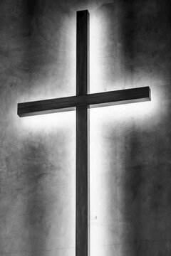 A cross mounted on a wall with light illuminating the back; Nelson, Nelson Province, New Zealand