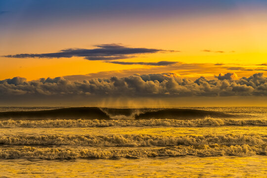 View of breaker waves and surf with low lying clouds in the sky at sunset; South Shields, Tyne and Wear, England, United Kingdom