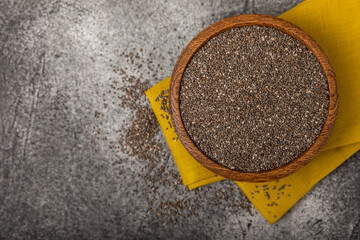 Chia seeds in a wooden bowl on a black marble background. Superfood. Healthy food. Diet. Antioxidant. Place for text. Place to copy.