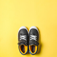 Gray and yellow sneakers on yellow background