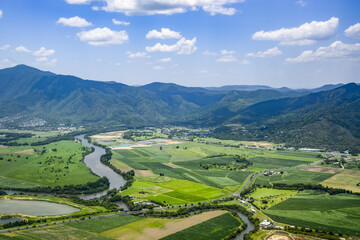 Cape York Peninsula, on the East coast of Australia, with views of lush farmland, a river and mountain range; Queensland, Australia