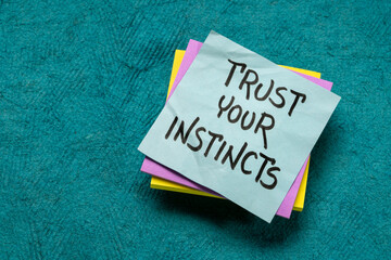 Fototapeta na wymiar trust your instincts - advice or motivational reminder on a sticky note, confidence and personal development concept