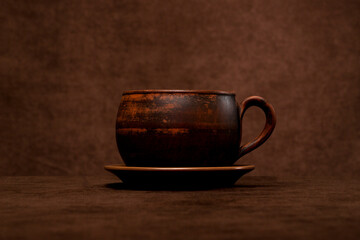 Large brown clay cup on a brown background