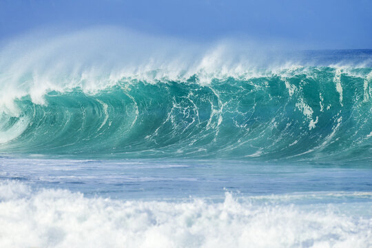 Large turquoise ocean wave cresting before reaching the shore; Oahu, Hawaii, United States of America