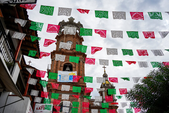 Historical Church of Our Lady of Guadalupe and decorative flags hanging from lines across the street; Puerto Vallarta, Jalisco, Mexico