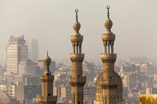 View overlooking the minarets of the Mosque of Sultan Hassan at the Citadel and the and the Al-Rifai Mosque at Midan al-Qal'a, with the hazy sky over the city skyline in the background; Cairo, Egypt