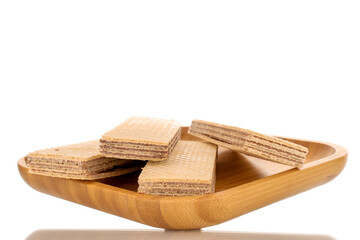 Several sweet chocolate wafers on a wooden plate, close-up, isolated on a white background.