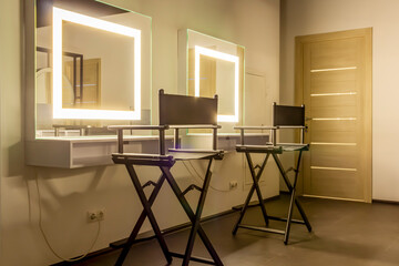 Workplace of the hairdressers with illuminated mirrors and comfortable chairs. Premium coworking...