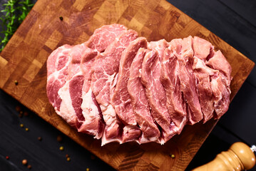 Fresh raw beef steak on wooden cutting board, top view. Served over black background. Web design banner with copy space. Organic healthy fresh food concept. Meat diet, cooking process.