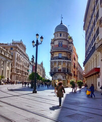Fototapeta na wymiar A beautiful image of people walking and strolling in the morning sunlight along a famous avenue in the beautiful city of Seville, Analuzia, Spain.