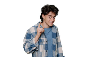 Teenager boy wearing blue plaid shirt over transparent background rises index finger, pensive expression. Smiling with cheerful face. Idea concept. Clever teen isolated on transparent studio backdrop.