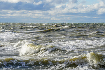 Stormy gray sea with white foam of waves during a hurricane storm