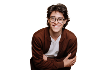 Cheerful caucasian guy in glasses, brown sweatshirt and white t-shirt posing at studio against transparent backdrop toothy smiles. Handsome male teenager indoors. Youth, happiness. Handsome people.