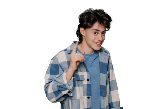Teenager boy wearing blue plaid shirt over transparent background rises index finger, pensive expression. Smiling with cheerful face. Idea concept. Clever teen isolated on transparent studio backdrop.