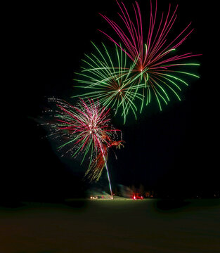 Bright fireworks in the dark sky in winter; Edmonton, Alberta, Canada