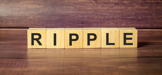 Word RIPPLE formed by alphabet blocks on brown background