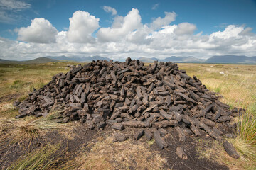 Turf cut and stacked in a pile of peat bricks along the Bog Road (Bothar na Scrathog) in Connemara; Carraroe, County Galway, Ireland