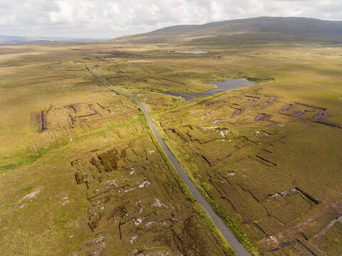Aerial View of the Bog Road (Bothar na Scrathog) leading through cut peat bogs in  Connemara; Carraroe, County Galway, Ireland