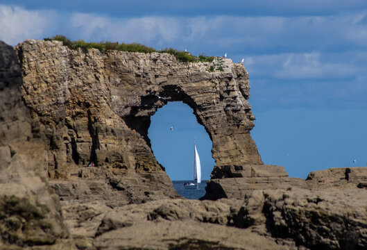 Wherry viewed through a natural arch rock formation; Whitburn Tyne and Wear, England
