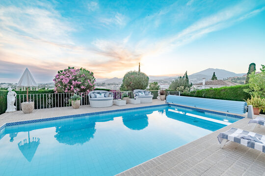 a garden image full with deck chairs and a swimming pool along the Costa Del Sol close up 