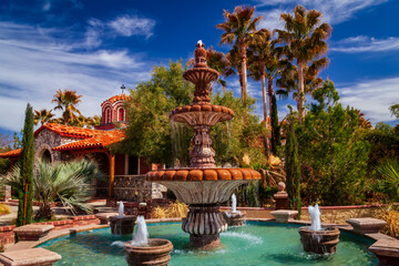 Beautiful, lush garden and ornate water fountain beside The Chapel of St Nicholas at St Anthony's Greek Orthodox Monastery; Florence, Arizona, United States of America
