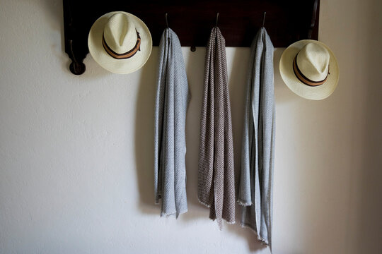 Hats and pashminas on a coat rack on a wall in Nine Skies Bungalow boutique hotel in Demodra, Hill Country, Sri Lanka; Demodra, Badulla District, Sri Lanka