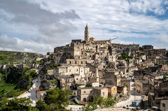 Cityscape of the mountaintop town of Sassi di Matera and its ancient cave dwellings with the bell tower of the Matera Cathedral overlooking the city; Matera, Basilicata, Italy