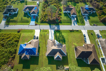 Hurricane Ian damaged house rooftop covered with protective plastic tarp against rain water leaking...