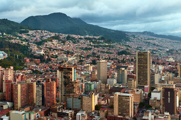 Fototapeta na wymiar View of the center of the city of Bogota from the top of Torre Colpatria tower, Colombia. Cityscape with houses and mountains in the background under cloudy sky.