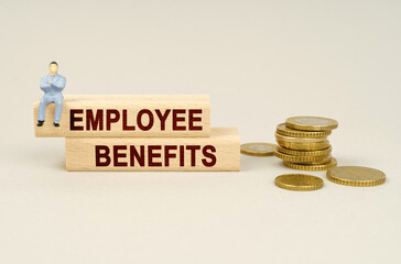 On the table are coins, wooden plates with the inscription - Employee benefits