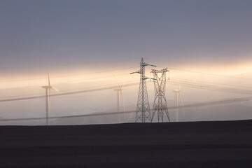 .Wind generation towers behind high tension lines in the desert of Peru