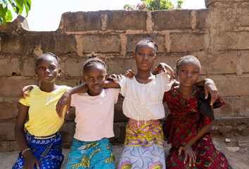 Front view of four pretty African classmates symbolising friendship and togetherness among girls