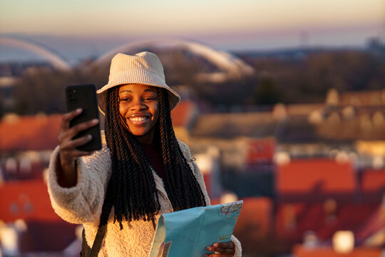 Beautiful tourist taking a picture with her phone after sites seeing all day in a new city, she's a student in a new city for winter holiday break