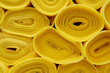 Closeup of many rolls of soft fabric in yellow color