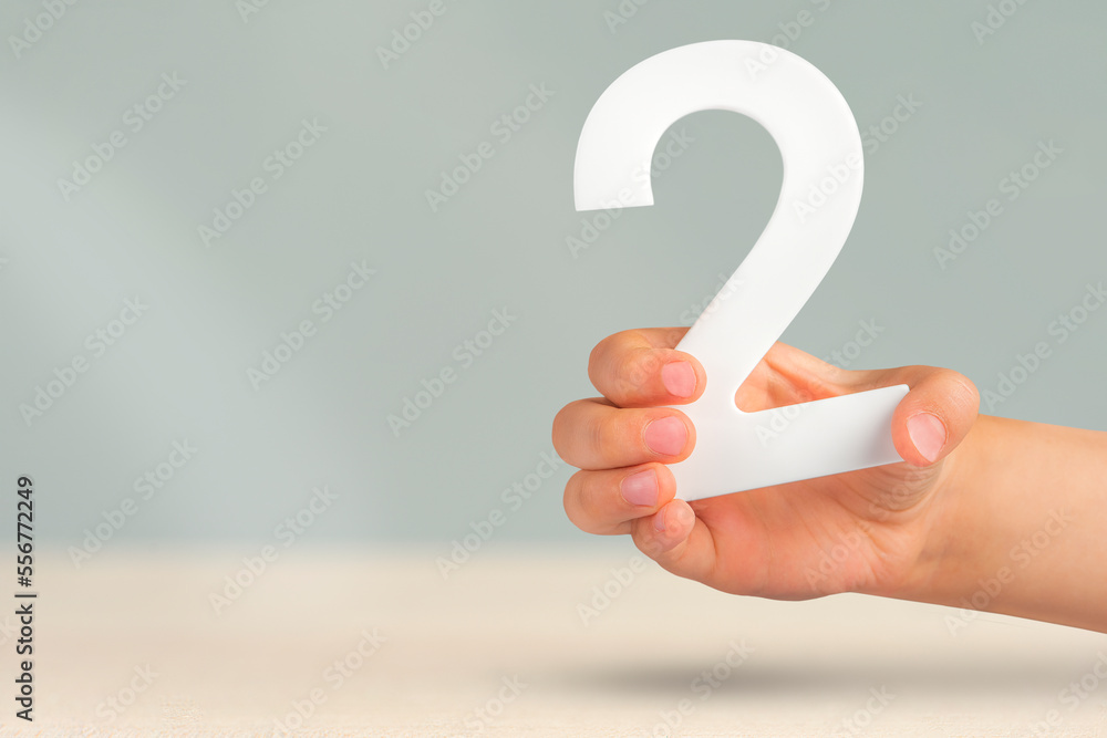 Aufkleber Number two in hand. Hand holding white number 2 on blurred background with copy space. Concept with number two. 2 percent, birthday 2 years old, couple, two, double