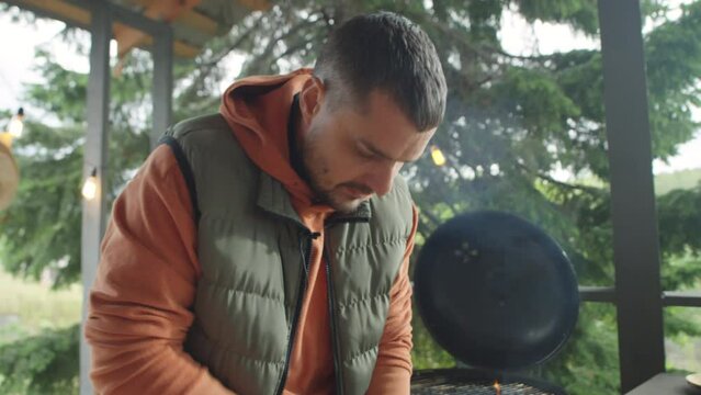 Food blogger shredding red cabbage with knife and speaking on camera while giving online cooking masterclass on outdoor terrace
